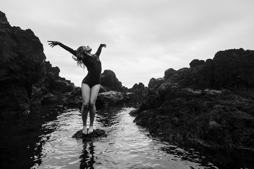 Tânia en mouvement sur un rocher, au bord de l’eau