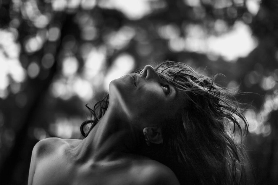 Portrait en noir et blanc de Tânia, la tête tournée vers le ciel