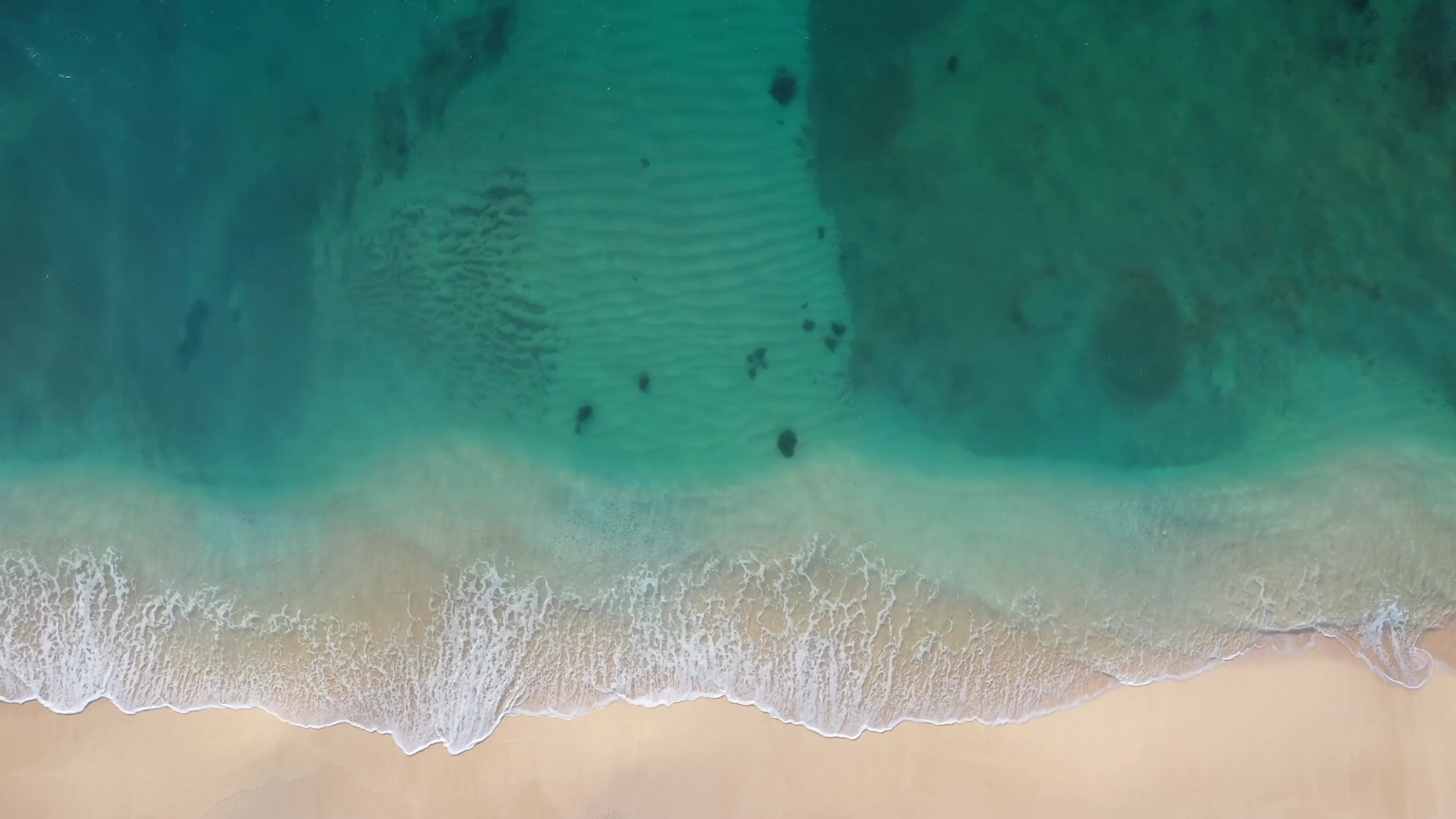 La mer vue du dessus, le sable et l’eau claire